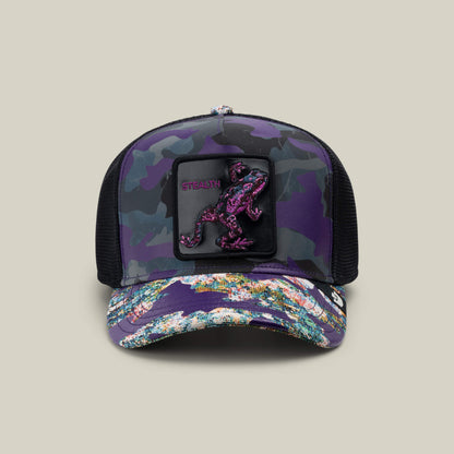 The Silent But Deadly trucker hat by Goorin Bros. features an ENERGY purple camo design, multicolored brim, black mesh sides, and a front patch with a pink and black lizard—ideal for fans of Stealth frog caps or Frogs of War style.