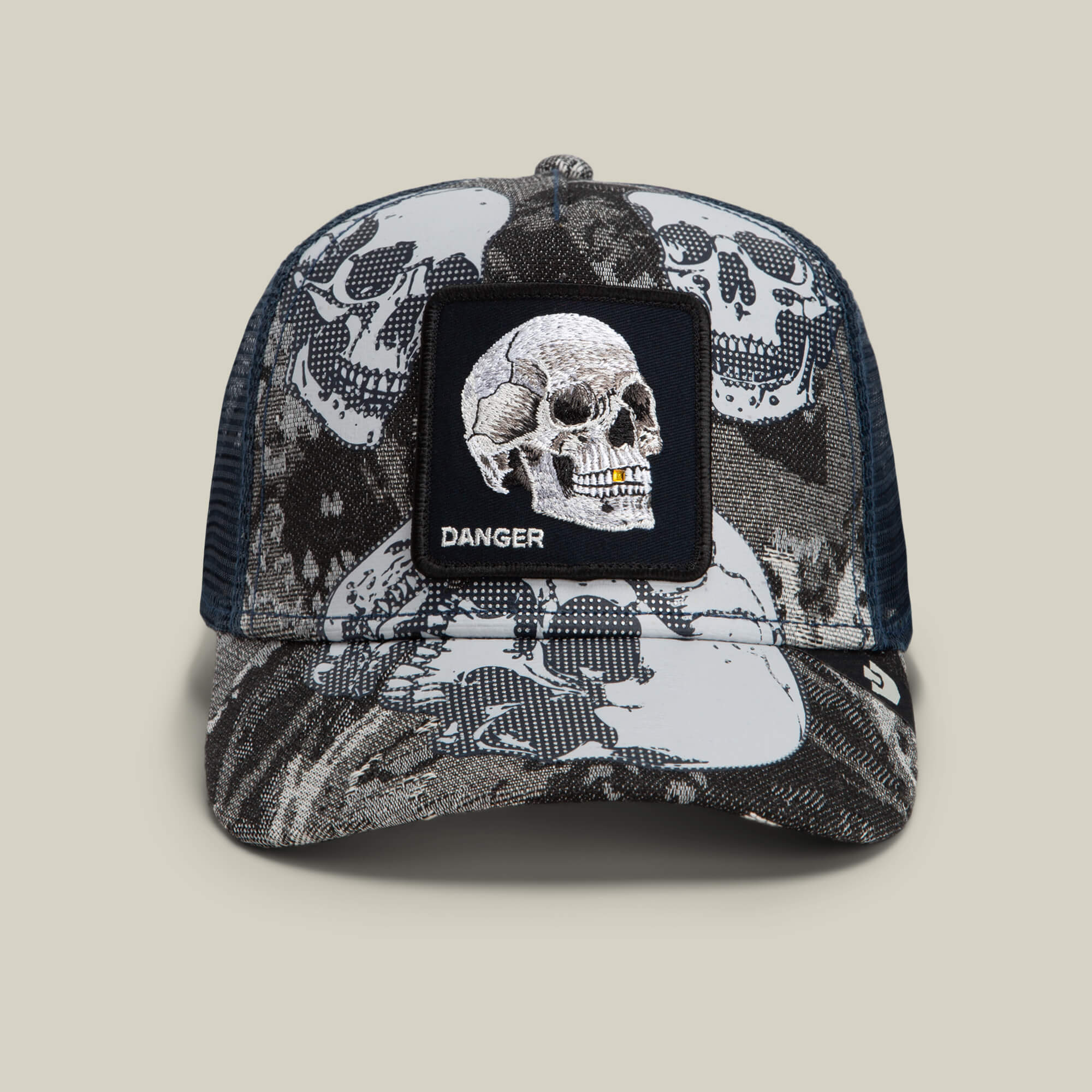 Goorin Bros. Bone Head Danger trucker cap in Edge, featuring a black and gray mesh back, skull graphics, and a front patch with an embroidered skull and the word “DANGER”.