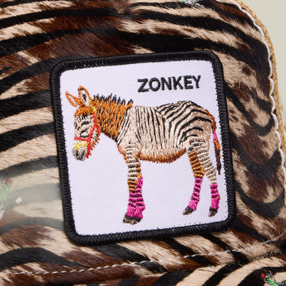 A fabric patch with an embroidered zonkey—half zebra, half donkey from Africa—wearing pink leg wraps, sewn onto zebra stripes. "ZONKEY" is stitched above in true Tijuana Special style. Product: Tijuana Special by Goorin Bros.