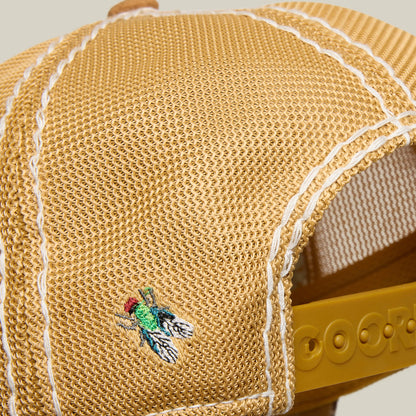 A close-up of the Goorin Bros. Tijuana Special: a yellow mesh baseball cap with white stitching and an embroidered green and black Tijuana Special fly near the back.