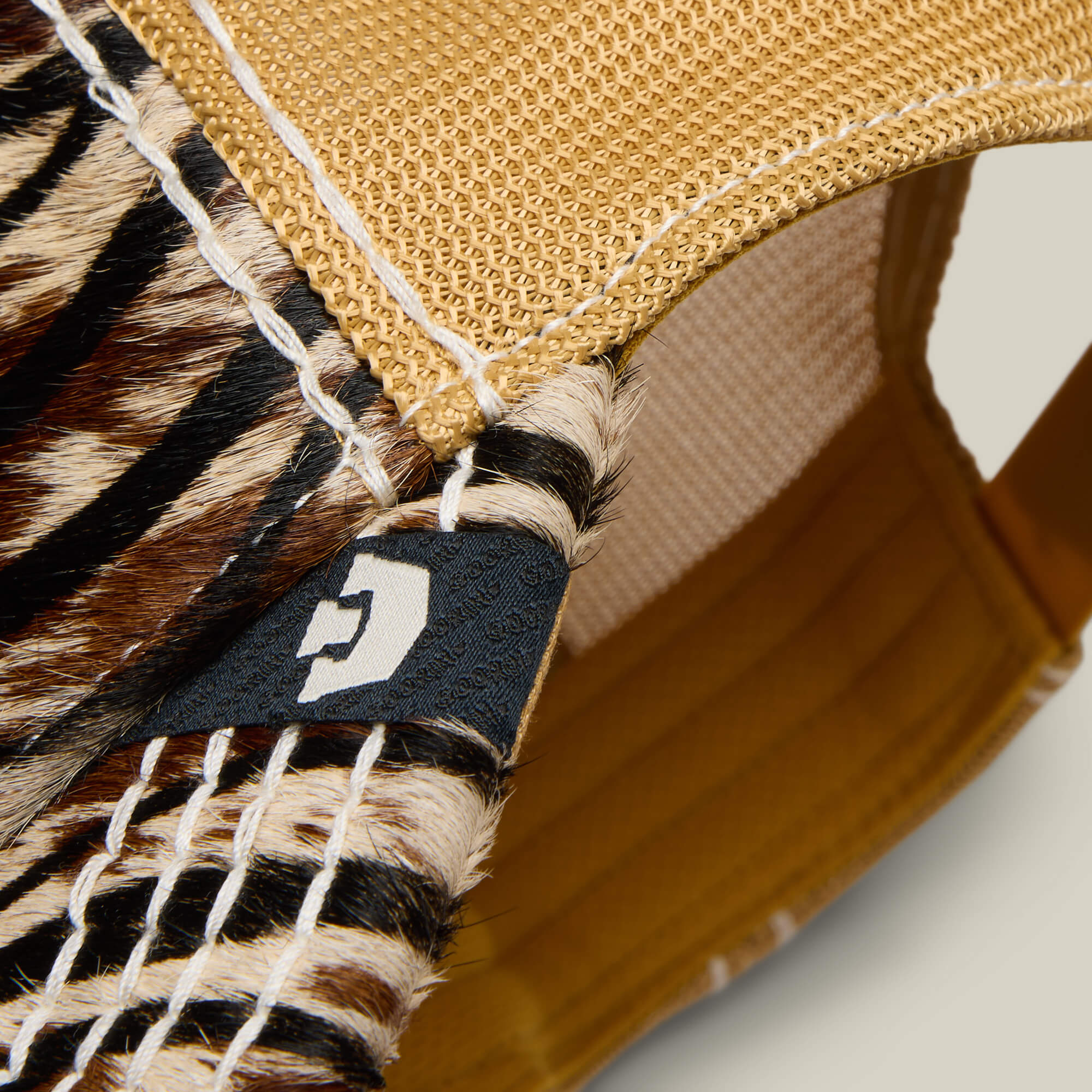 Close-up of the Goorin Bros. Tijuana Special hat, featuring animal print fur, a tan mesh interior, tan stitching, and a black tag with a white "C".