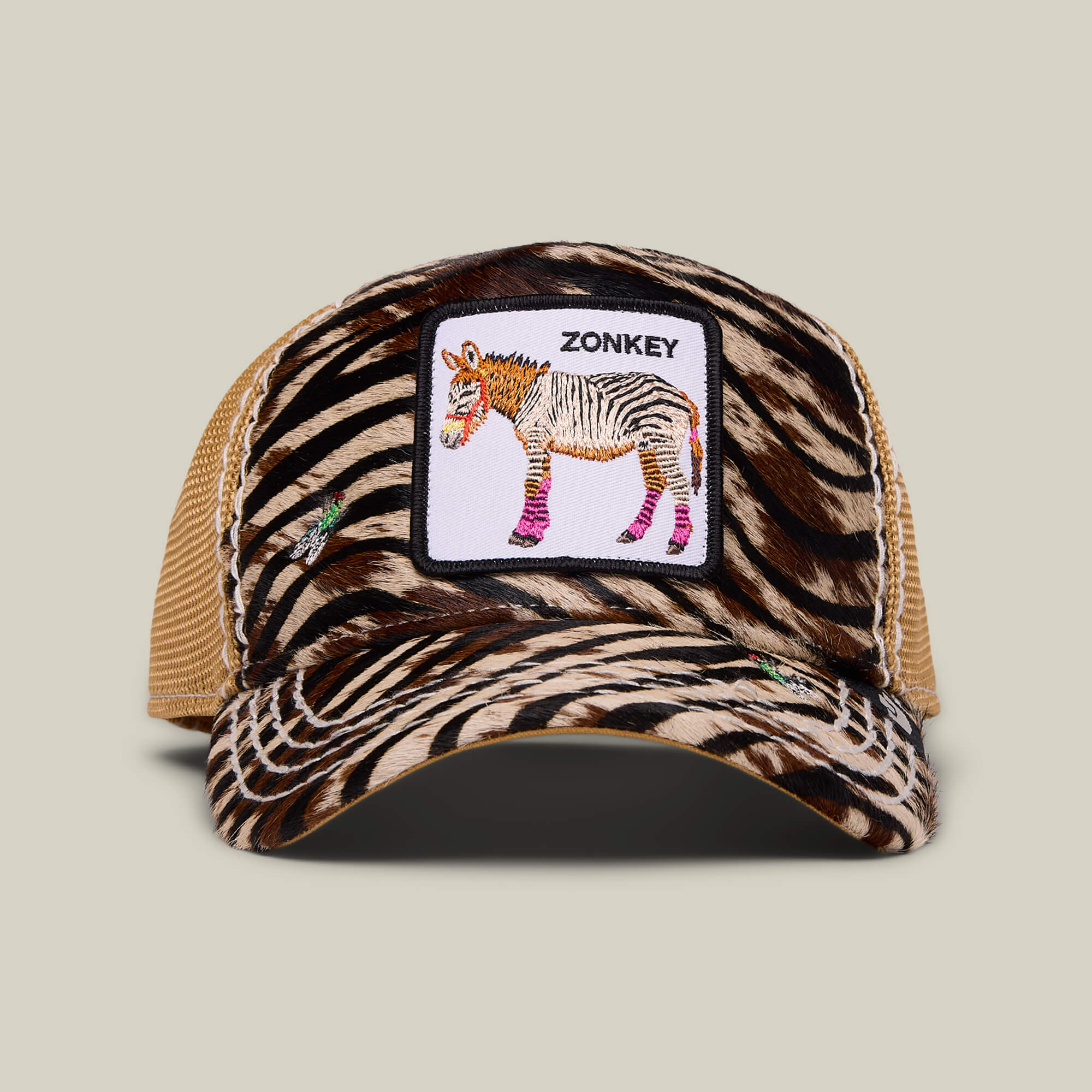 The Tijuana Special by Goorin Bros. features an amber zebra-print trucker hat with mesh back and a front patch of a cartoon zonkey labeled ZONKEY—celebrating Africa's unique spirit in standout style!.