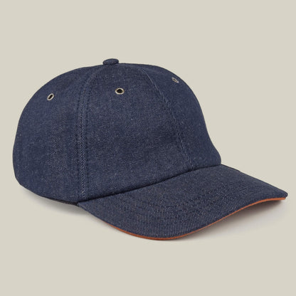 The Goorin Bros. Legend Ridge is a dark blue denim baseball cap made in the USA, featuring a curved brim and metal eyelets, shown against a plain beige background.