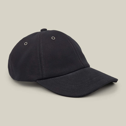 The Goorin Bros. Mineral Road black mixed-material baseball cap, featuring visible stitching and metal eyelets, made in the USA, is shown on a neutral beige background.