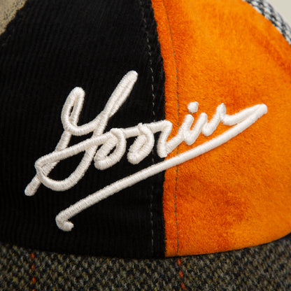 A close-up of the "South Bay" Papa hat by Goorin Bros., featuring textured panels in black, orange, and gray with "Yorin" embroidered in white Goorin Script on the front.