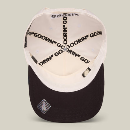 An inside view of the white and black Goorin Bros. Mildly Remarkable Script hat, featuring GOORIN branding on the inner seams, script embroidery, and a small label under the brim.