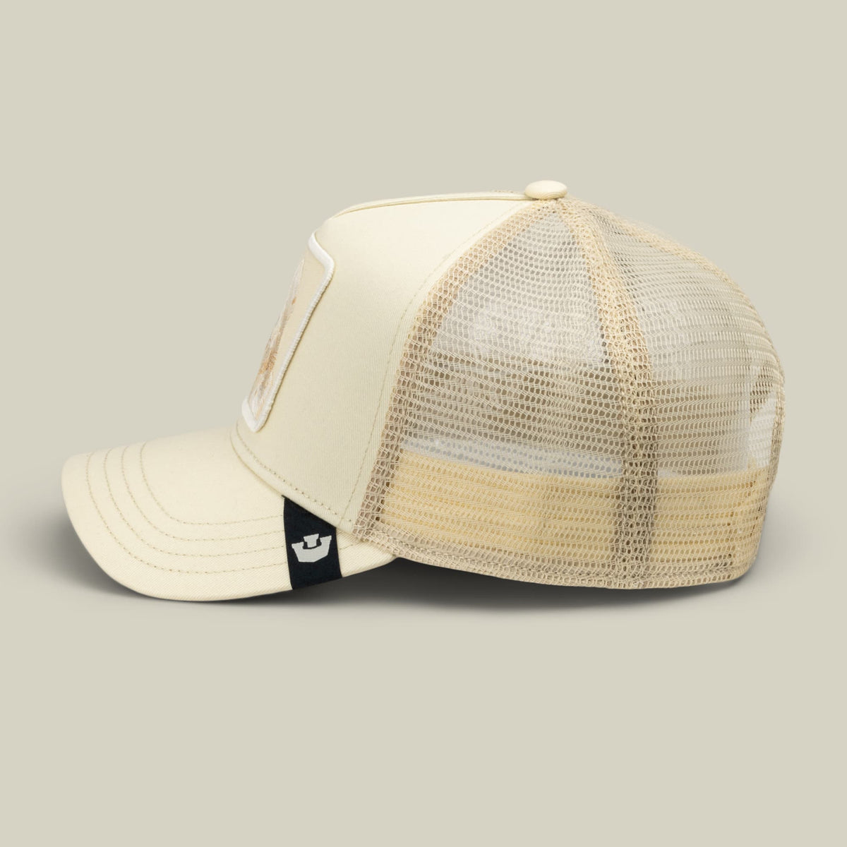 The Goorin Bros. Tonal Amigo trucker hat features a cream canvas front panel and beige mesh back with a small black brand patch on the side, photographed against a neutral background.