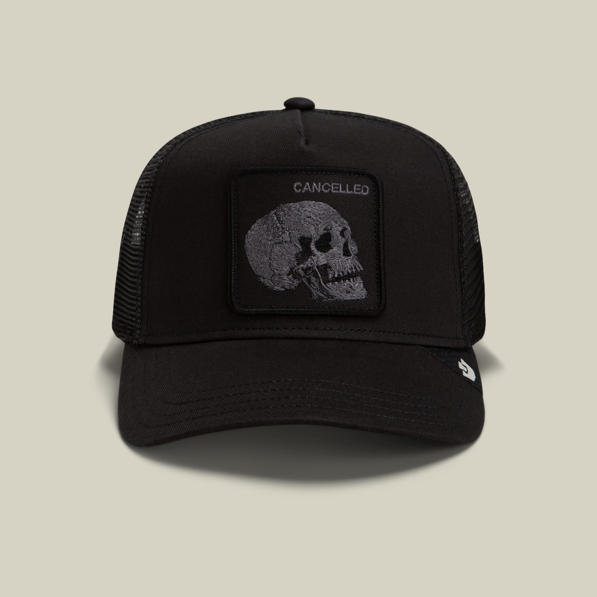 The Goorin Bros. Tonal Skull trucker hat features a black mesh back with a solid black front panel displaying a gray skull patch embossed with "Cancelled" text, shown against a neutral background.