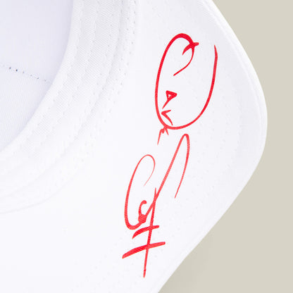 Close-up of a white fabric item from Goorin Bros.’ Dave Scott My Beautiful Lion, featuring a red abstract drawing and signature-style mark on the surface.