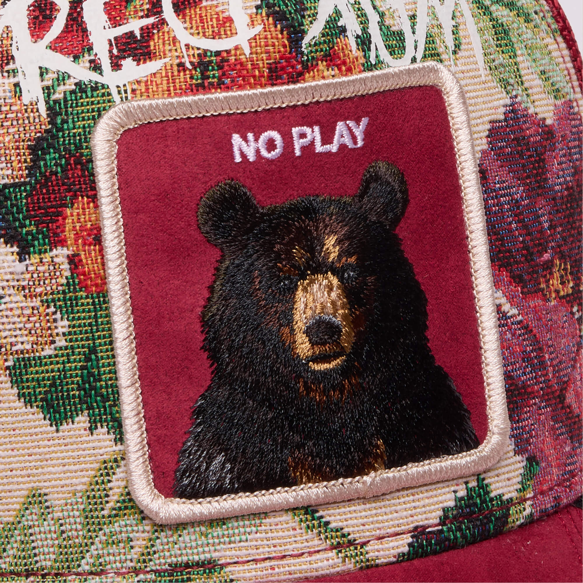 Dull Boi by Goorin Bros. is a fabric patch featuring an embroidered bear and "All Work and No Play" on a floral and burgundy background, perfect for Johnny’s Fresh Friday Drop collection.
