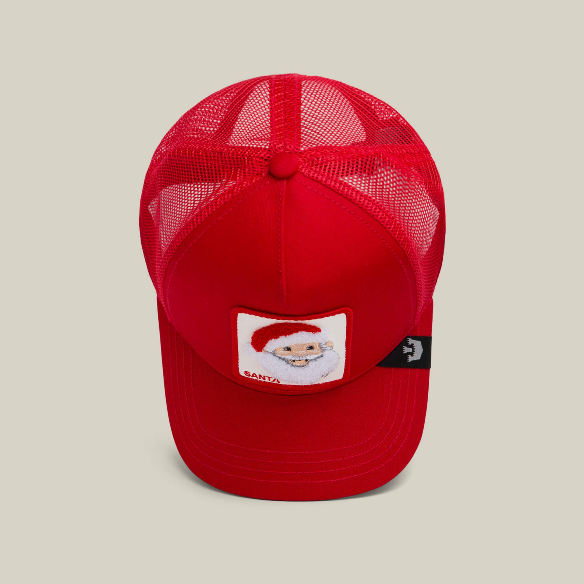The Goorin Bros. "Mr. Claus" red mesh trucker hat features a Santa Claus patch on the front, making it perfect for the holiday season, shown from above against a neutral background.