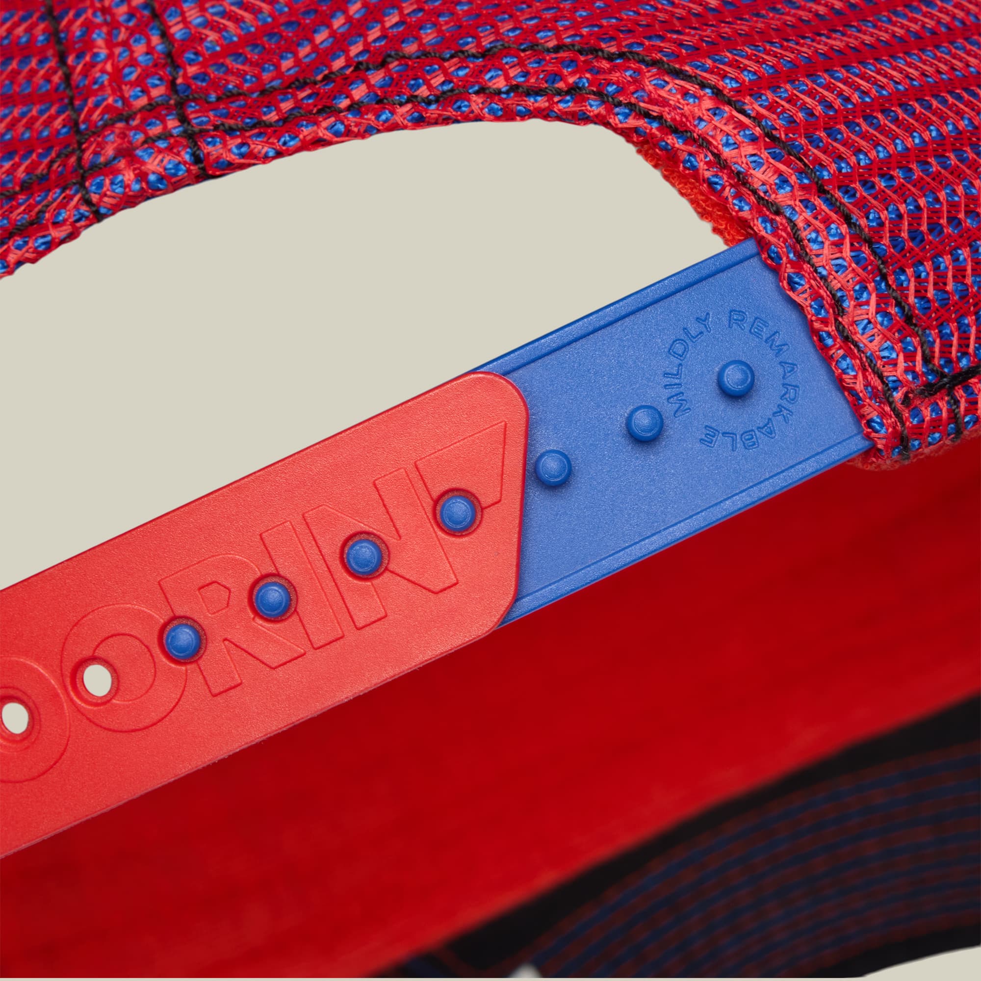 Bug Fixes by Goorin Bros is a red and blue mesh baseball cap with embroidered Nintendo Wii controller designs, displayed flat lay style on a cream background with red and blue fabric.