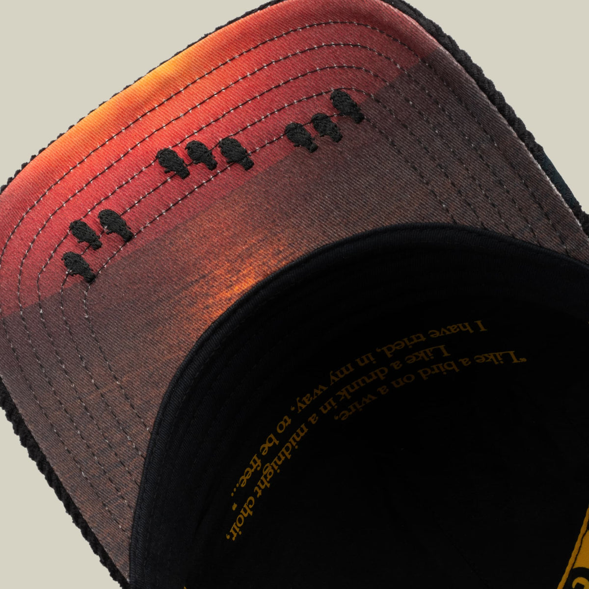 It Was The Hat bucket hat by Goorin Bros features a gradient design transitioning from orange to red to black, with embroidered black tree motifs across the crown and gold text on the black interior label.