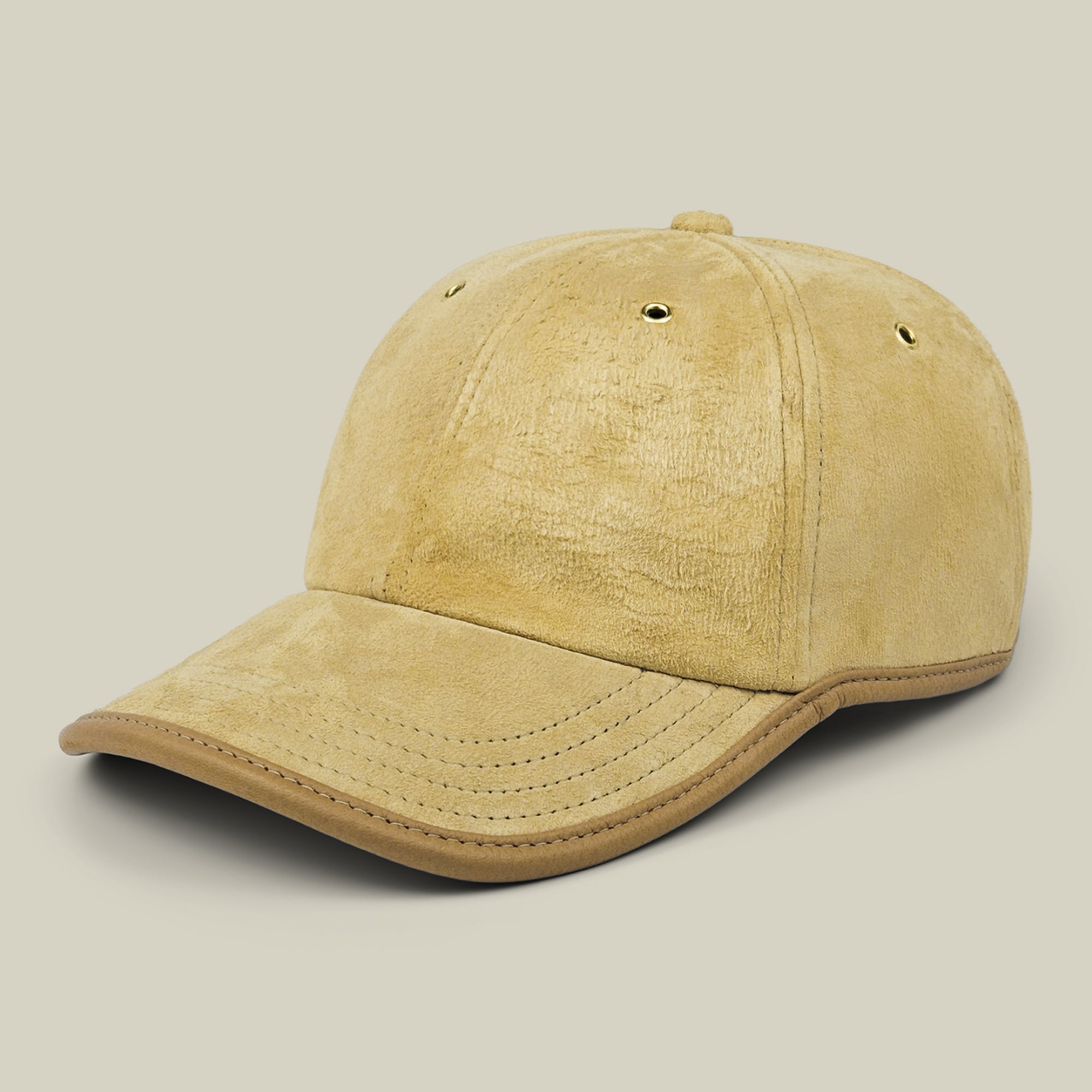 The Goorin Bros. Steiner papa cap in tan suede features visible stitching and a curved brim, complemented by an adjustable plaid strap at the back and two ventilation eyelets on each side, displayed against a plain light beige background.