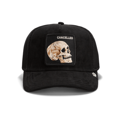 The Bold Suede Skull by Goorin Bros. is a limited edition trucker hat with a mesh back and a front patch featuring a stitched skull and the word "CANCELLED" above it.