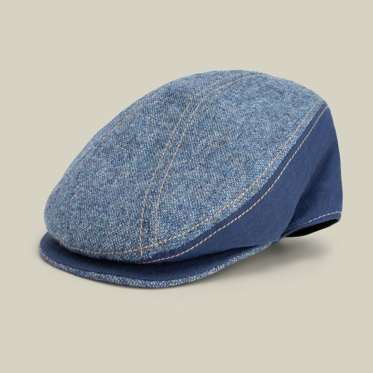 The Goorin Bros. Full Wattage flatcap in CELESTIAL offers a classic silhouette, crafted from tweed-like fabric with visible stitching, set against a plain beige background.
