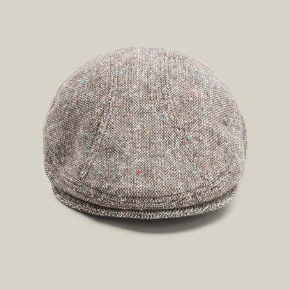 The Gibbins cap by Goorin Bros., in the color GROUND, features a speckled tweed design ideal for men's fashion and is showcased against a plain beige background.