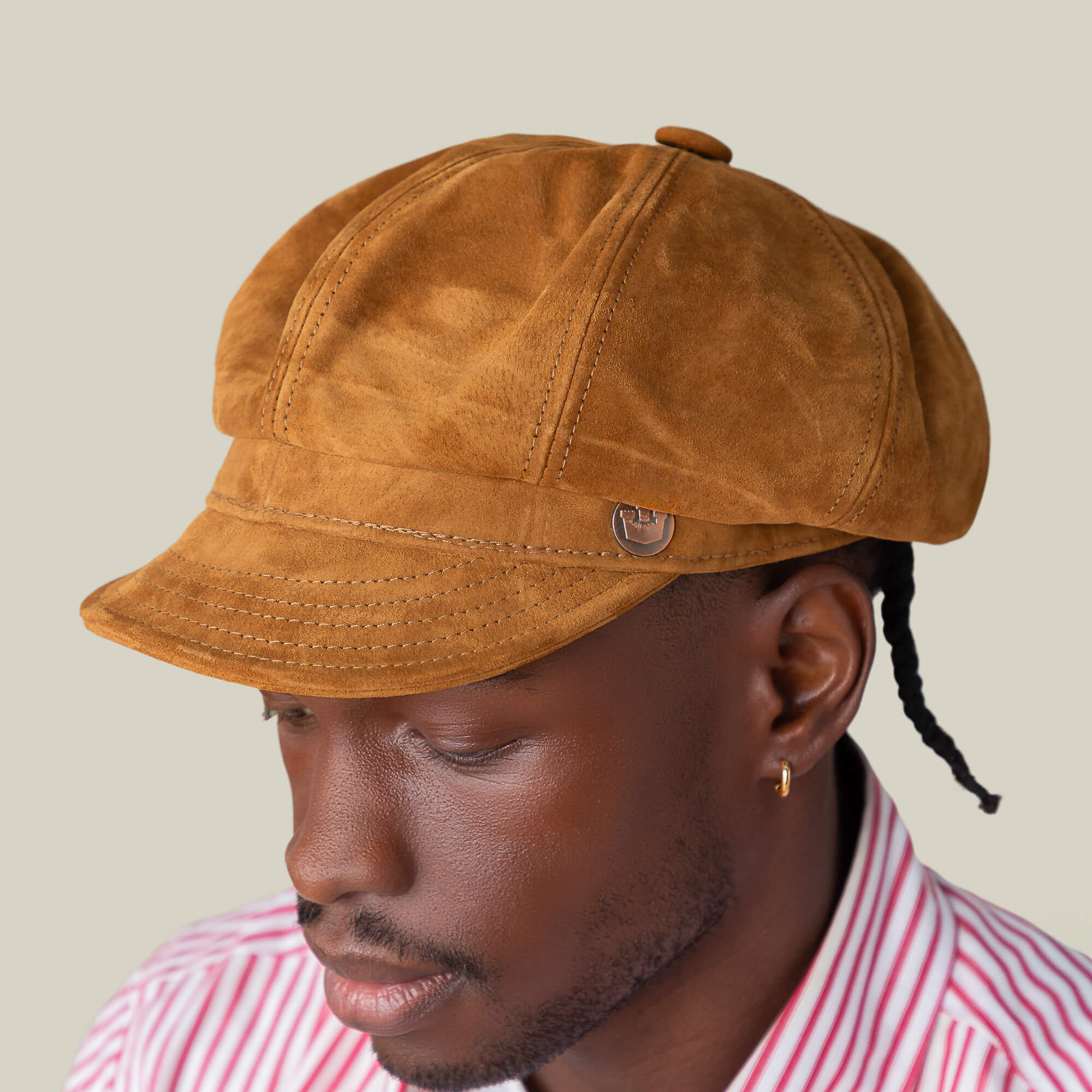 A person wearing the Goorin Bros. Ruthy suede cabbie flatcap and a red-and-white striped shirt, looking downward against a plain background.