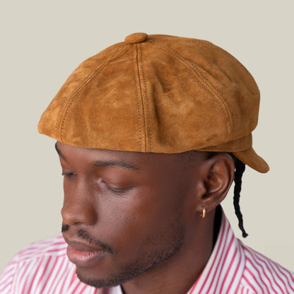 A man wearing the Goorin Bros. Ruthy suede cabbie flatcap and a red-and-white striped shirt, shown from the side against a plain background.