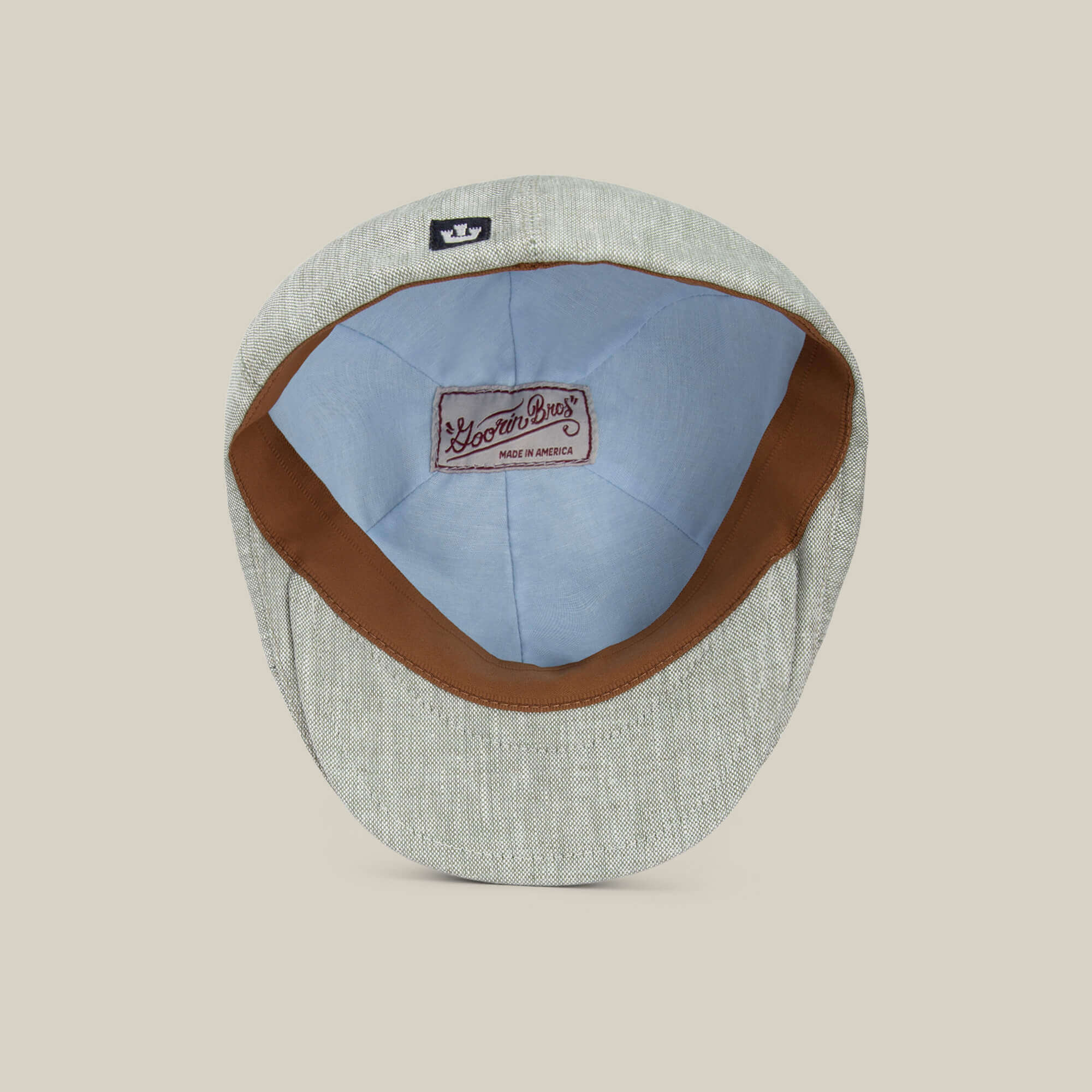 The Benjamin Paul flat cap by Goorin Bros. is shown from the inside, highlighting its brown leather sweatband, light blue lining, and a sewn Goorin Bros. label—an ideal three-season hat for everyday wear.