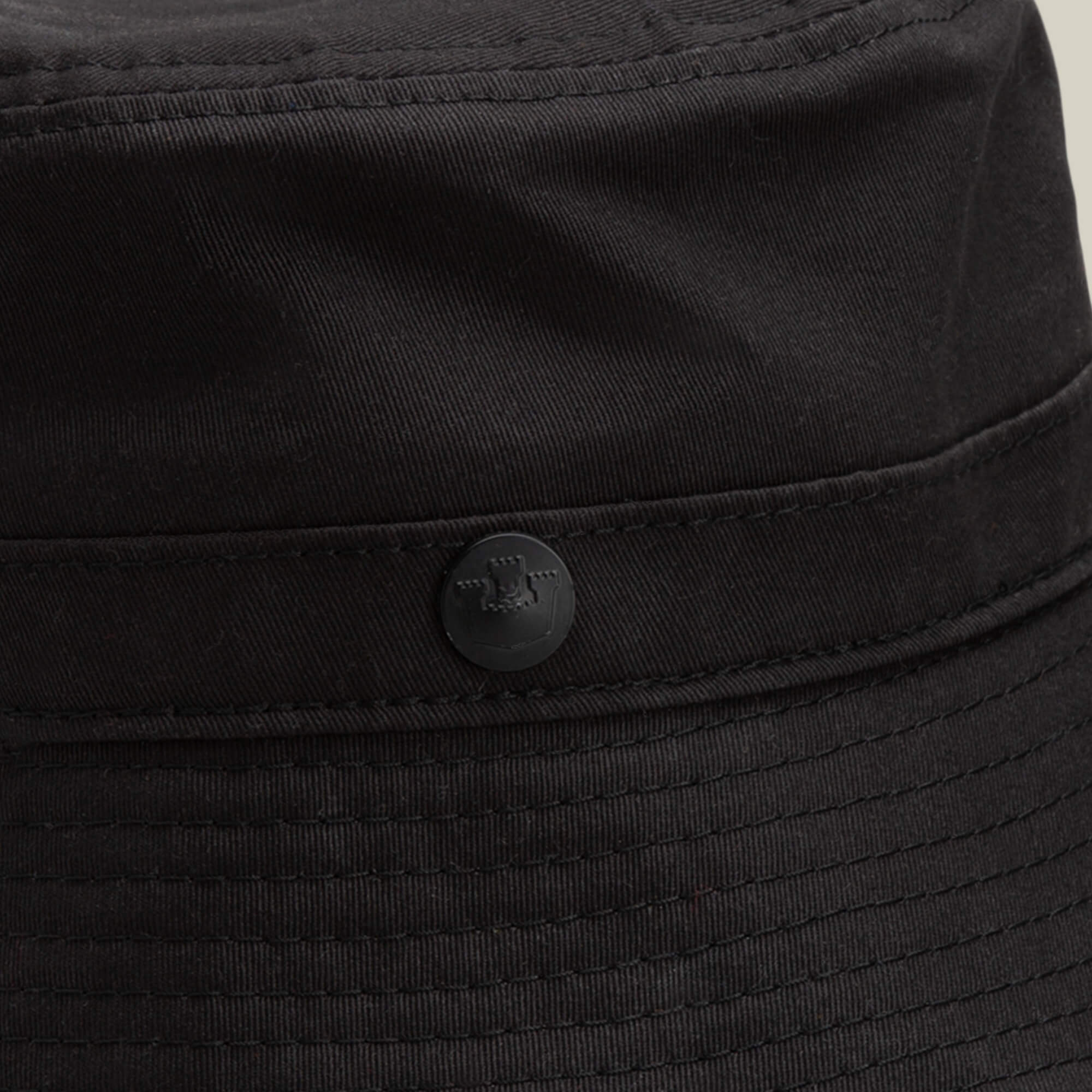 Close-up of the Goorin Bros. Odyssey Bucket hat in solid black cotton, featuring visible stitching and a small round button detail on the side.