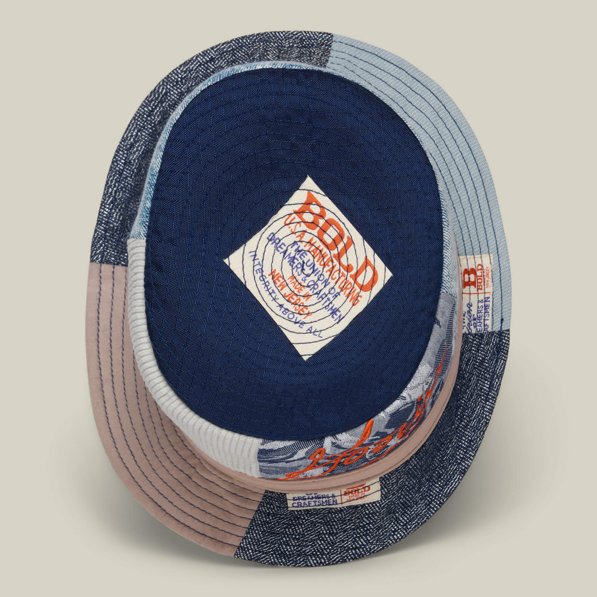 Overhead view of two Goorin Bros. Goorin Rework Bucket hats stacked together, highlighting their colorful patchwork design, fabric textures, and visible inside brand labels—each crafted from recycled materials.