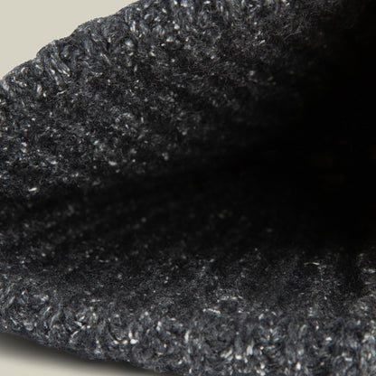 Close-up view of the opening of the textured, dark gray Northstar knitted fabric by Goorin Bros., possibly a beanie or sleeve.