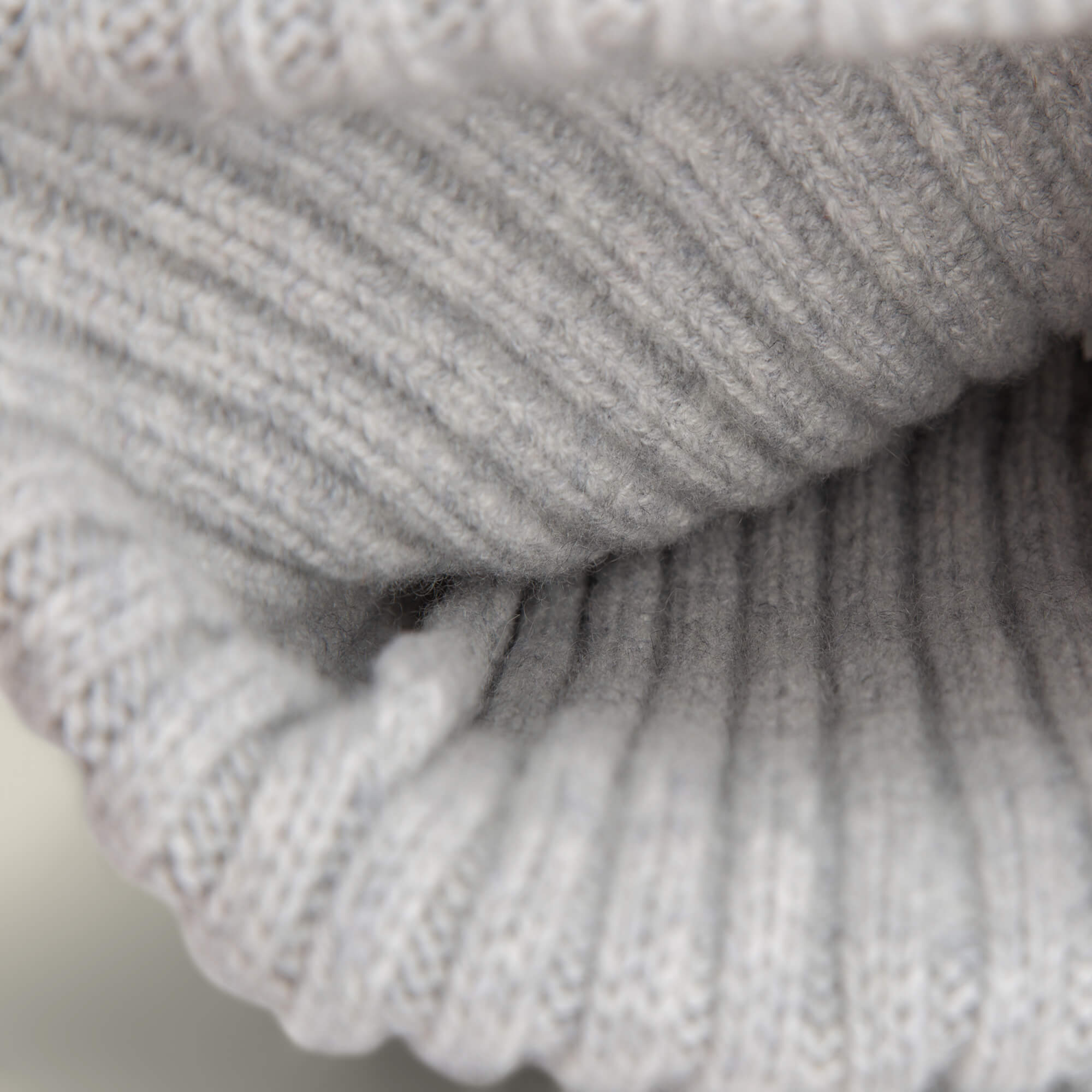 Close-up of the luxurious, light gray ribbed knit texture of the Dream Cap by Goorin Bros., highlighting its fine stitching and soft cashmere wool.