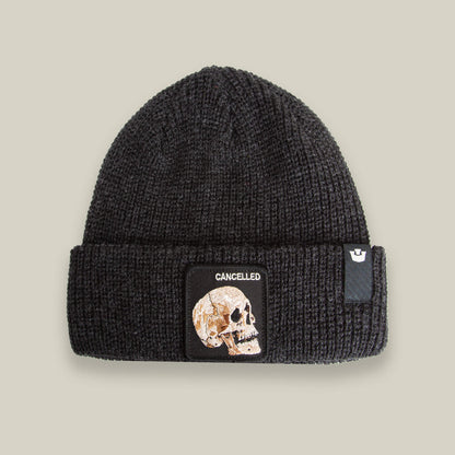 The Cancelled Beanie by Goorin Bros. in VOID features a black skull patch and "CANCELLED" front design, with a charcoal knit cuff, all showcased on a neutral background.