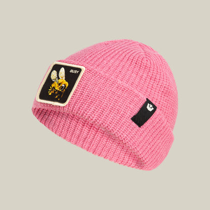 The Busy Beanie by Goorin Bros. is a pop-pink knit hat featuring a buzzing bee patch with "BUSY" on the front and a small black logo tag on the side.
