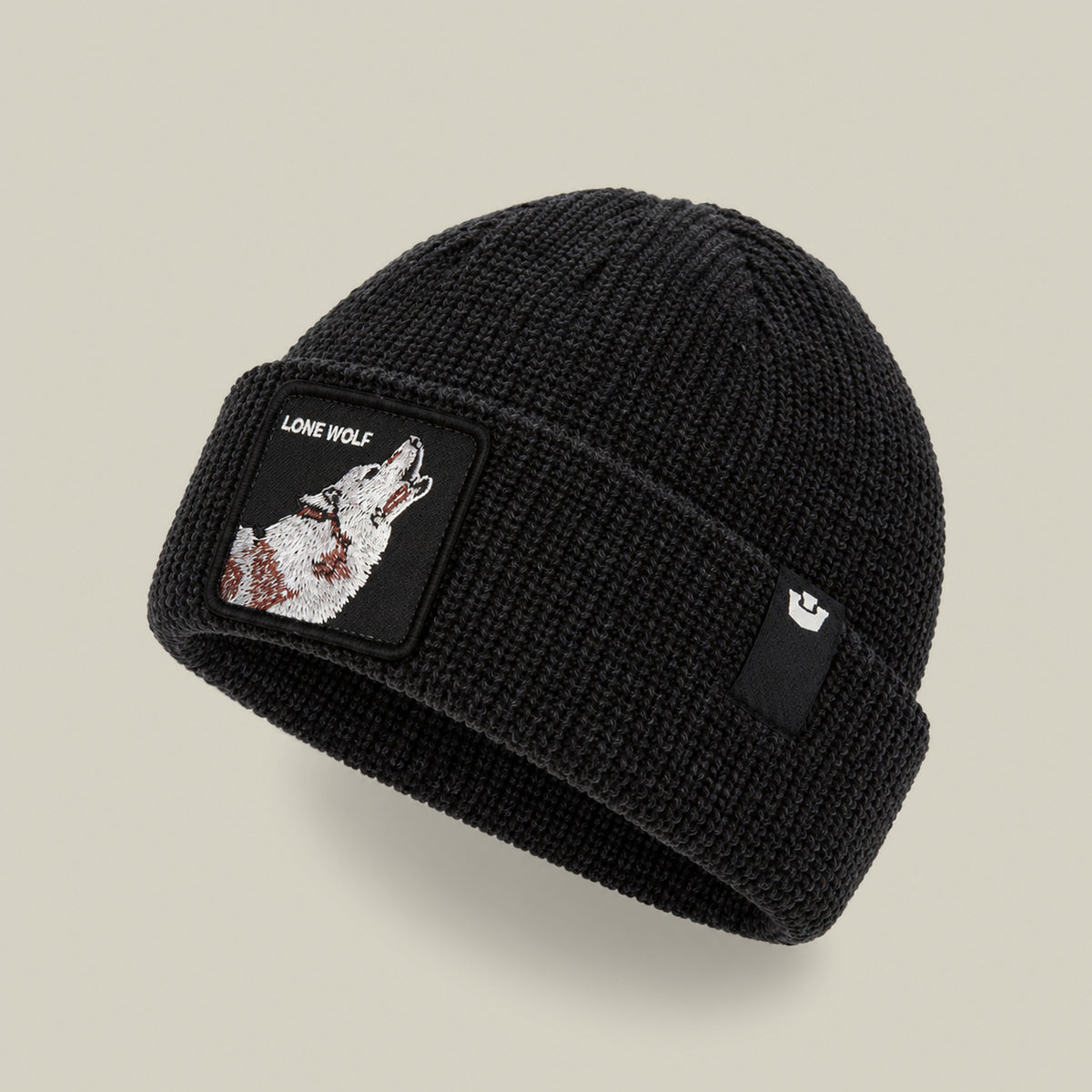 The Lone Wolf Beanie by Goorin Bros. is a black knit winter hat with a howling wolf “LONE WOLF” patch on the front and a small logo tag on the brim.