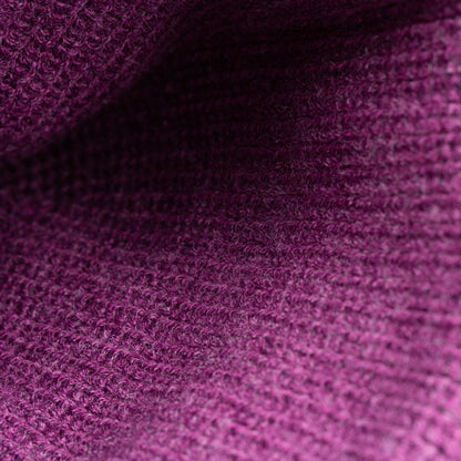 Close-up of The Frenchie Beanie by Goorin Bros.—a textured, plum knit fabric with a ribbed pattern and visible fibers, perfect for cozy street style.