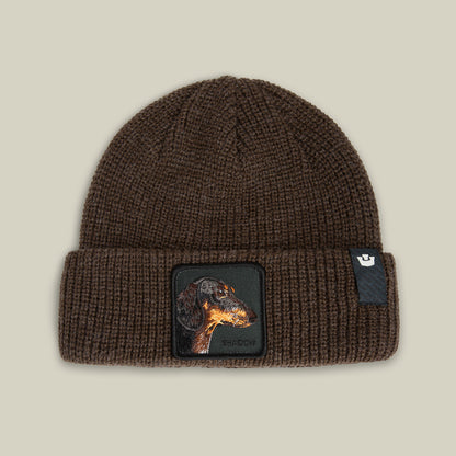 The Shadow Beanie by Goorin Bros. in GROUND features a dachshund patch and a small black tag on the folded brim.