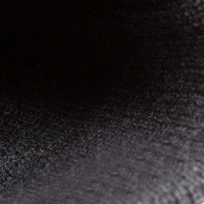 Close-up image of the textured black surface of The Beware Dog Beanie by Goorin Bros., showcasing visible fibers and a gradient of light and shadow—highlighting the heavyweight knit material.