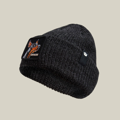 The Beware Dog Beanie by Goorin Bros. is a dark gray heavyweight knit beanie with a dog patch labeled "BEWARE" and a small black cuff tag—perfect for fans of guard dog beanie styles.