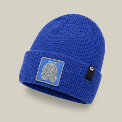 The Double Stuffed - Bunny Beanie by Goorin Bros. is a blue knit hat with a folded rib-knit cuff, featuring a patch with a gray bunny and the word “BUNNY,” along with a small black Goorin Bros. tag.