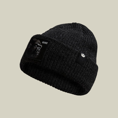 The Boss Beanie by Goorin Bros is a black ribbed knit beanie featuring an embroidered animal patch on the front and a small logo patch on the side, displayed against a neutral background.