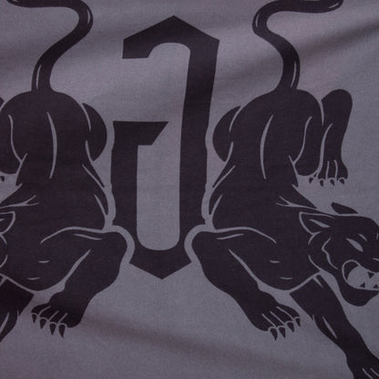 A graphic design of two black panthers facing away from a large, stylized letter J on gray decorates the Panther Crest Blanket by Goorin Bros.—the perfect luxury throw.