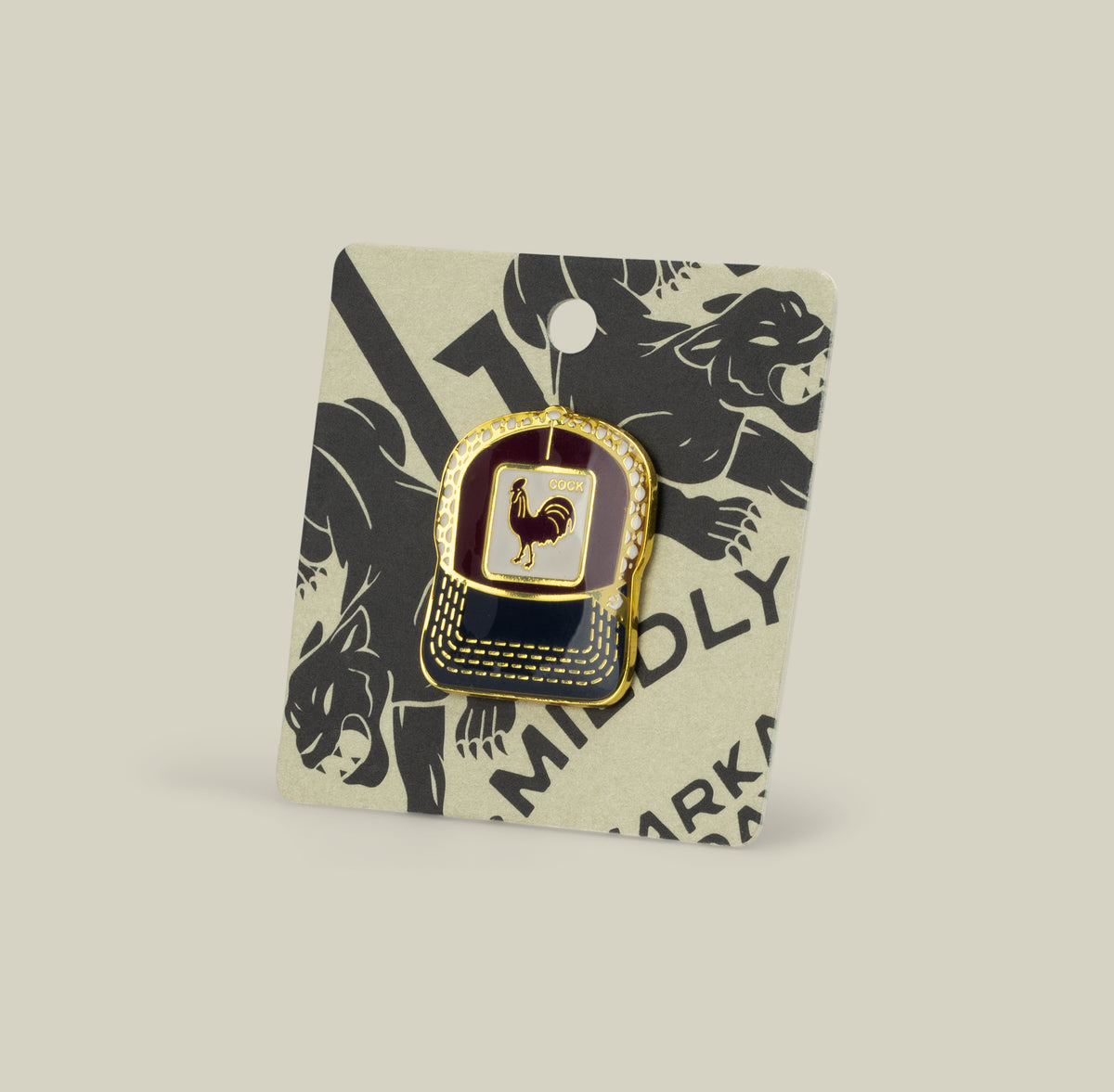 The Goorin Bros. Rooster Trucker Pin, gold and black with a rooster design, is shown on a card decorated with black animal illustrations.