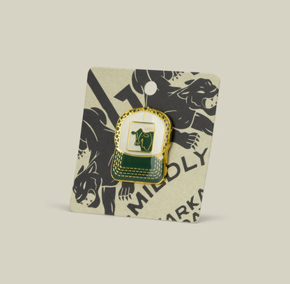 The Cash Cow Trucker Pin by Goorin Bros. is a green and gold enamel zinc alloy pin, attached to a beige card with black puma illustrations.