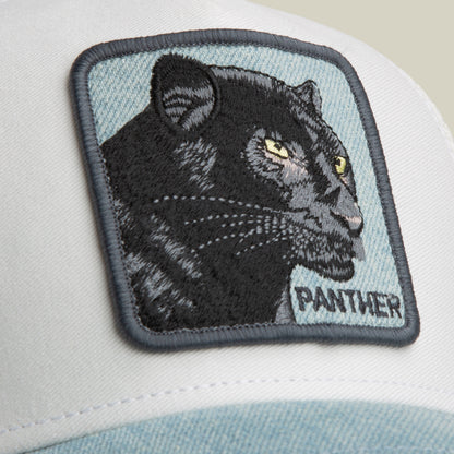 Introducing the Goorin Bros. Denim Panther: a low-profile trucker hat in white and light blue, featuring a denim brim and an embroidered patch with a black panther and “PANTHER” in bold capital letters.