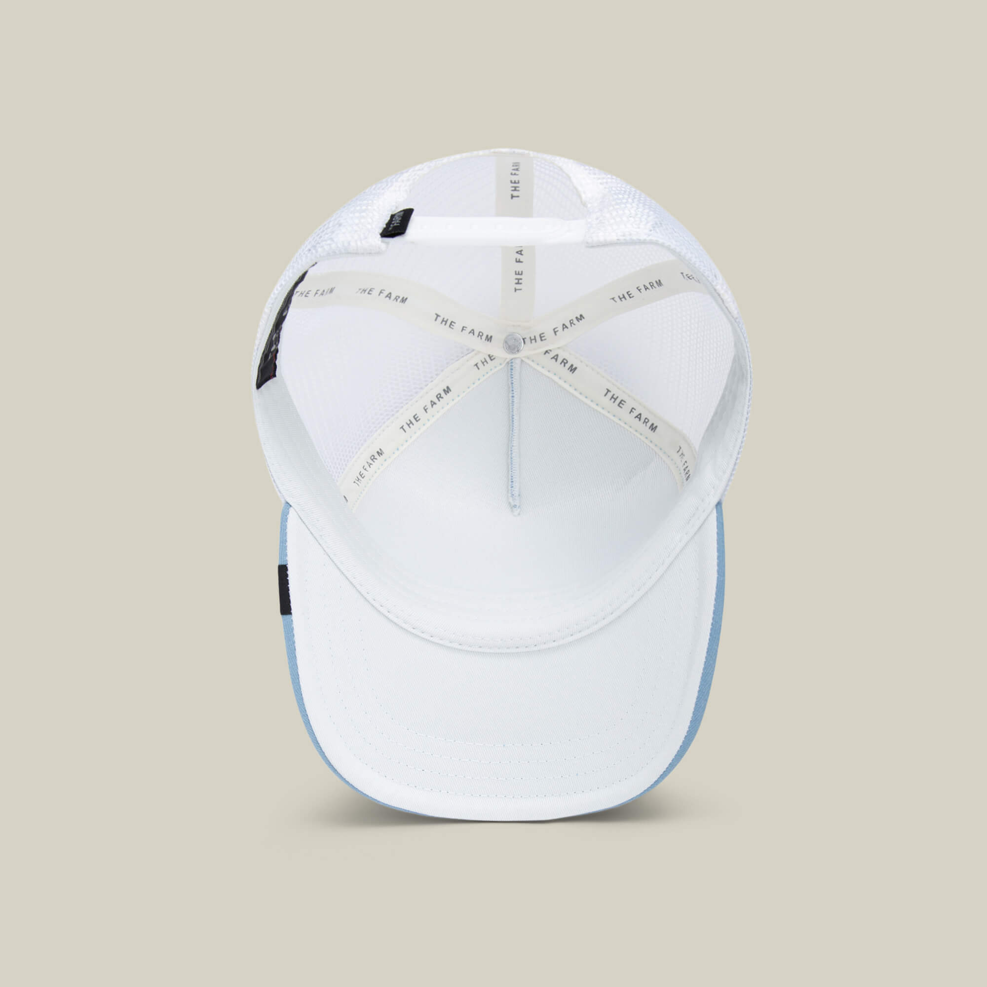 A top view of the Goorin Bros. So Big kids cap with a white crown, light blue brim, inside stitching, THE FARM branded tape, and sky blue mesh for breathability.