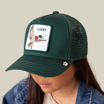 The Lucky Duck Mini by Goorin Bros. is a kid-sized dark green mesh baseball cap with a green crown, featuring a flying duck patch and “LUCKY” embroidered above it.