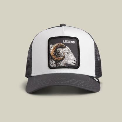 The Goorin Bros. Legend Trucker Mini is a white and charcoal mesh trucker hat with an embroidered ram head patch labeled "Legend" on the front, shown against a neutral background.