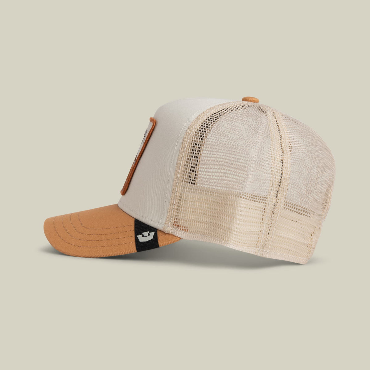 The Goat Trucker Mini by Goorin Bros is a colorblock trucker hat featuring a white front panel, cream mesh back, tan bill, and orange lower visor with a small black logo patch. The hat is displayed against a neutral background.