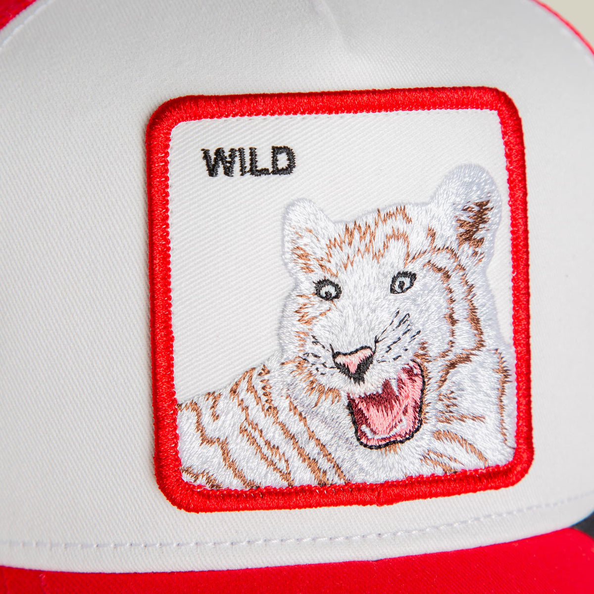 The Goorin Bros. Wild Tiger Mini is a red and white trucker hat featuring an embroidered tiger patch with brown and white detailing on the front panel.