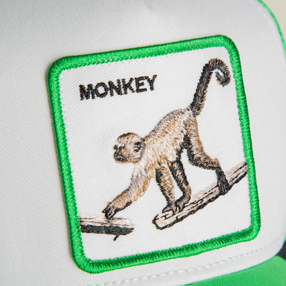 The Goorin Bros. Monkey Mini trucker hat features a green and white color block design with an embroidered monkey patch on the front panel.