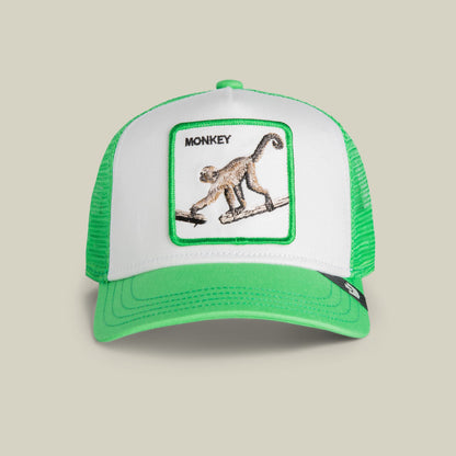 The Goorin Bros. Monkey Mini trucker hat features a green and white mesh design with an embroidered monkey patch on the front panel against a neutral studio background.
