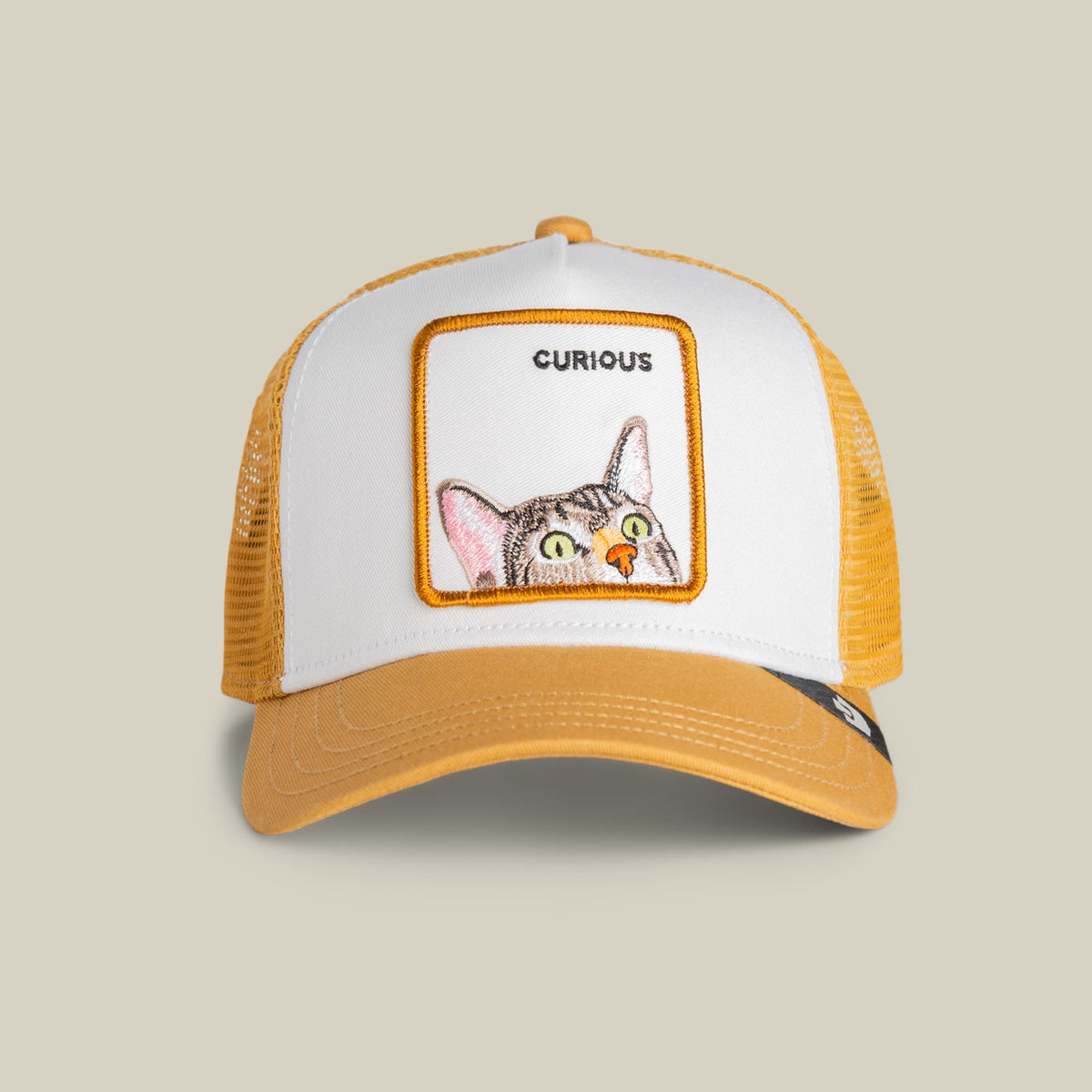 The Goorin Bros. Curious Cat Mini is a white and yellow mesh trucker hat featuring an embroidered patch of a curious cat with green eyes and the word "Curious" on the front panel, shown against a neutral background.