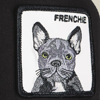The Goorin Bros. Frenchie Trucker Mini is a black and white trucker hat featuring an embroidered French bulldog patch with yellow-green eyes on the front panel.
